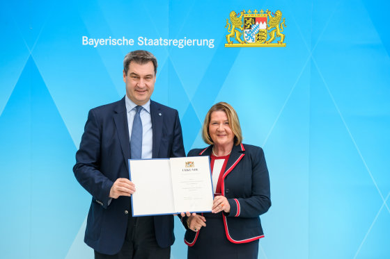 Ministerpräsident Dr. Markus Söder, Ehrenamtsbeauftragte Eva Gottstein, Ernennungsurkunde in den Händen, lächelnd